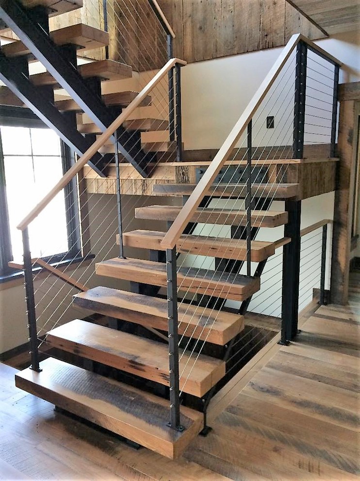Diseño de escalera suspendida rural de tamaño medio con escalones de madera, contrahuellas de metal y barandilla de cable