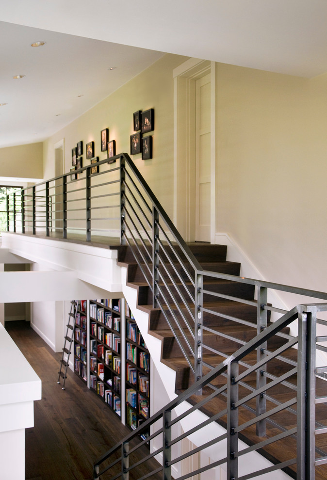 На фото: деревянная лестница в стиле неоклассика (современная классика) с деревянными ступенями с