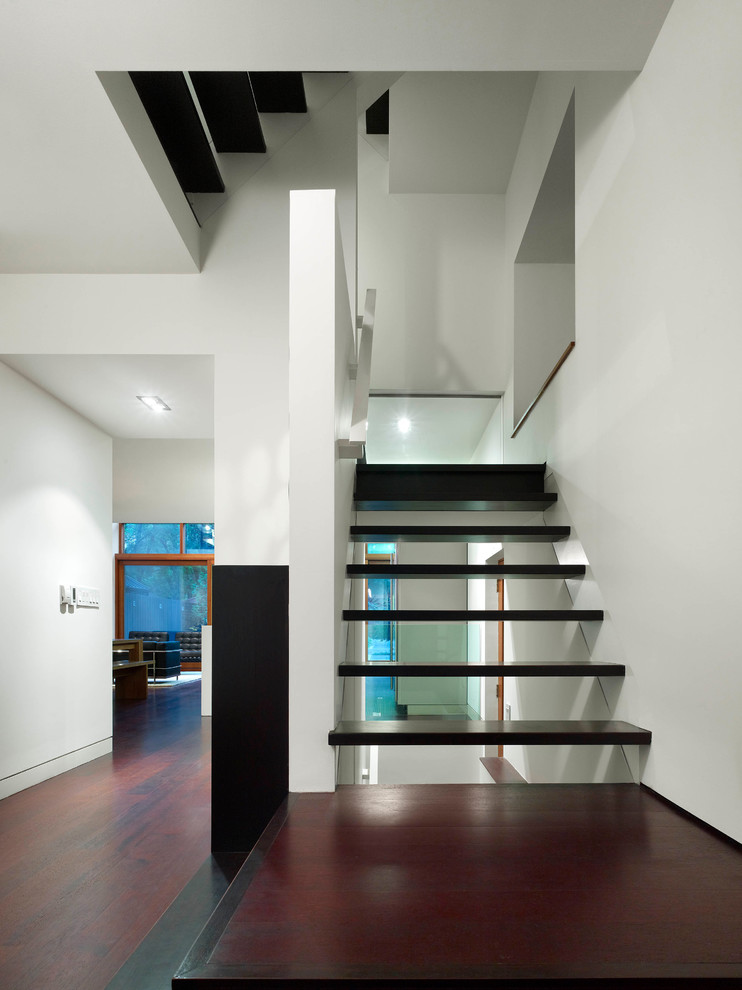 This is an example of a small modern wood u-shaped staircase in Toronto with open risers.