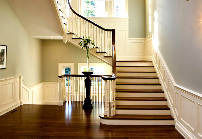 Imagen de escalera en L clásica de tamaño medio con escalones de madera, contrahuellas de madera pintada y barandilla de madera