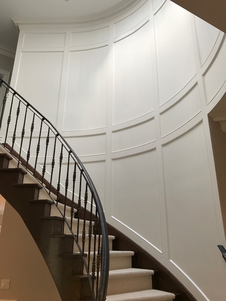 Imagen de escalera curva actual de tamaño medio con escalones de madera, contrahuellas con baldosas y/o azulejos y barandilla de madera