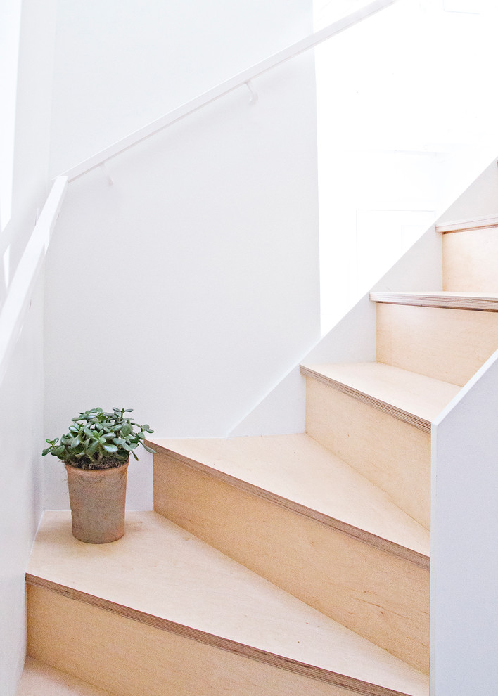 Idée de décoration pour un petit escalier nordique en L avec des marches en bois et des contremarches en bois.