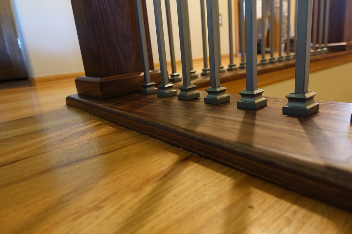 Diseño de escalera en L tradicional renovada pequeña con escalones enmoquetados, contrahuellas enmoquetadas y barandilla de madera