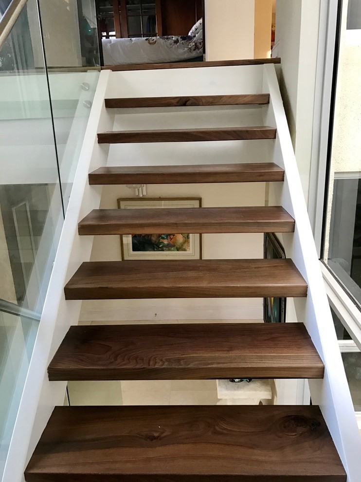 Modelo de escalera en U contemporánea de tamaño medio sin contrahuella con escalones de madera y barandilla de metal