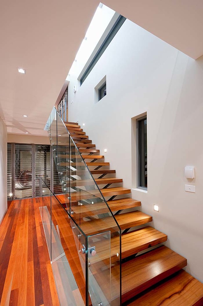 Aménagement d'un grand escalier droit contemporain avec des marches en bois.