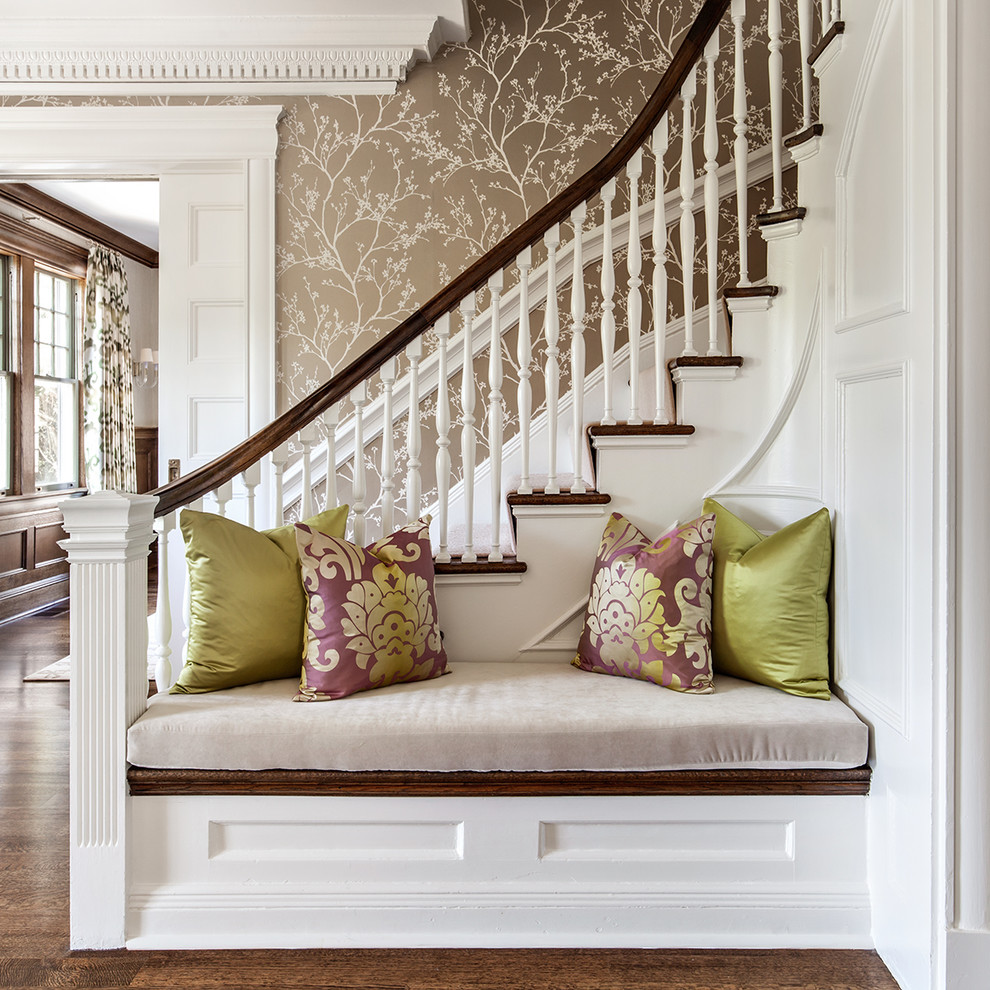 Свежая идея для дизайна: изогнутая лестница в классическом стиле с деревянными перилами - отличное фото интерьера