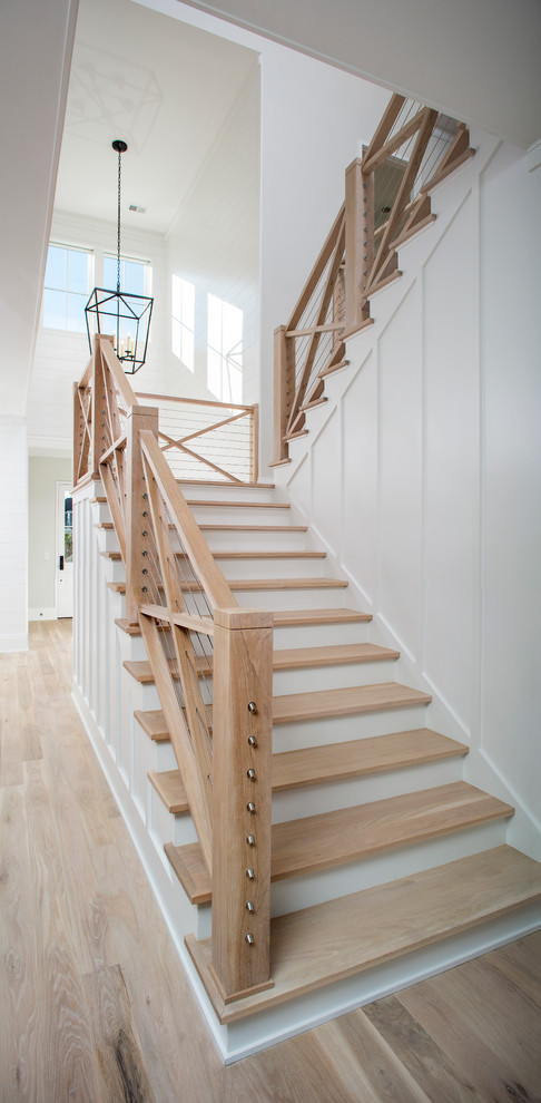 На фото: большая угловая деревянная лестница в морском стиле с деревянными ступенями с