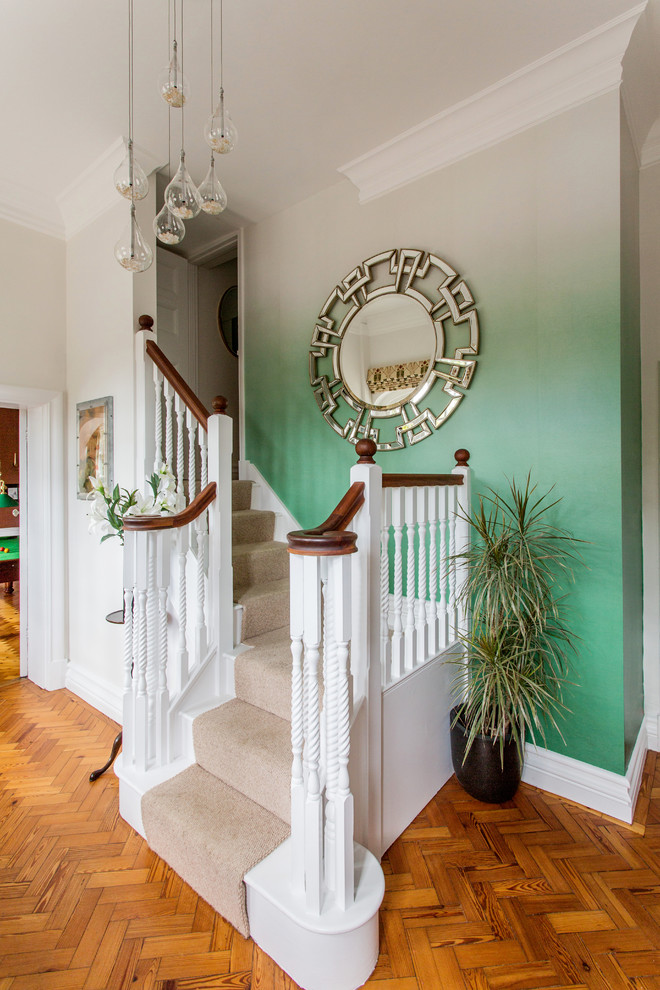 Medium sized eclectic carpeted l-shaped wood railing staircase in Oxfordshire with carpeted risers and a feature wall.