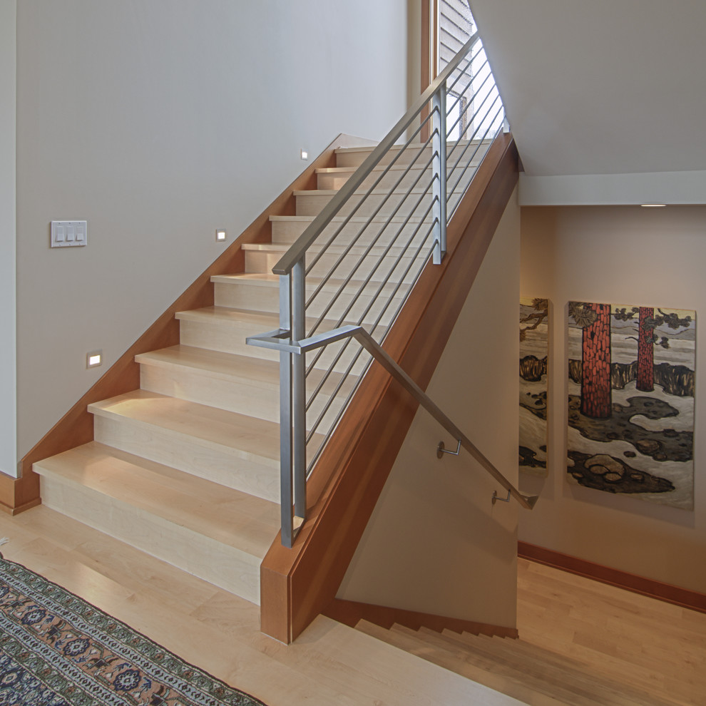 Cette photo montre un escalier tendance en U avec des marches en bois, des contremarches en bois et un garde-corps en métal.