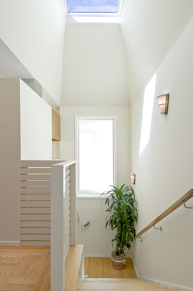 На фото: деревянная лестница в современном стиле с деревянными ступенями и деревянными перилами с