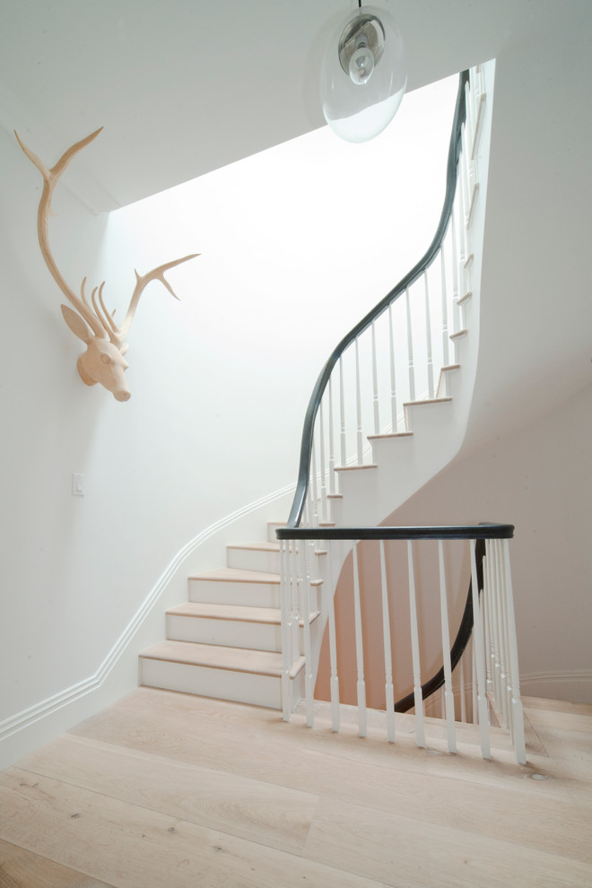 Inspiration för stora klassiska svängda trappor i trä, med sättsteg i målat trä och räcke i trä
