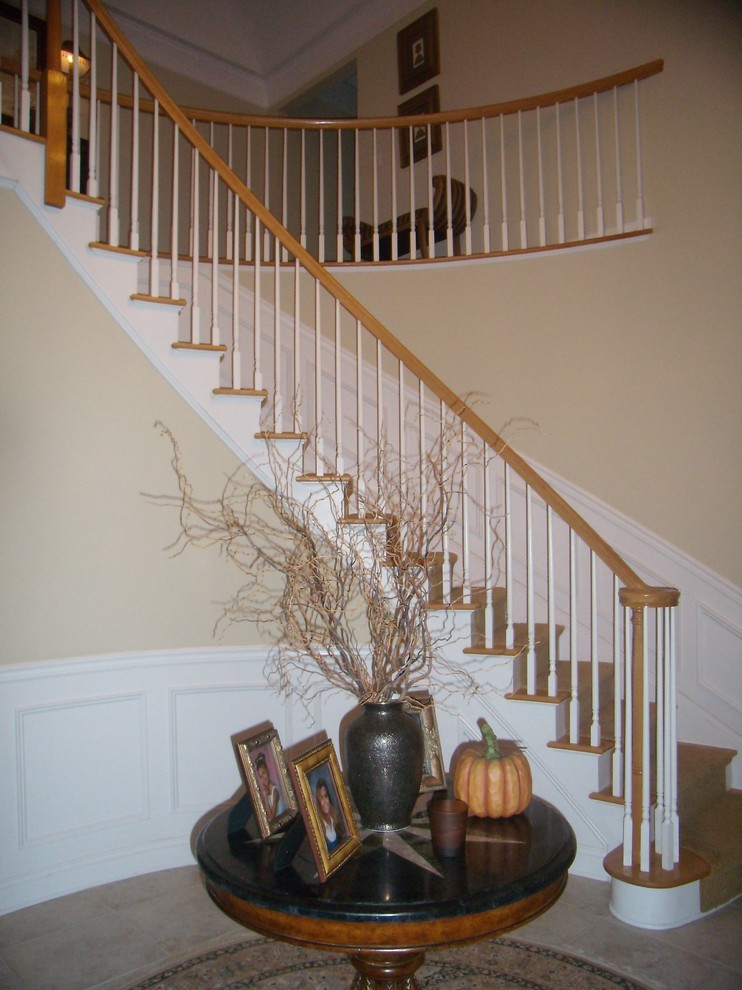 Large elegant wooden curved staircase photo in New York