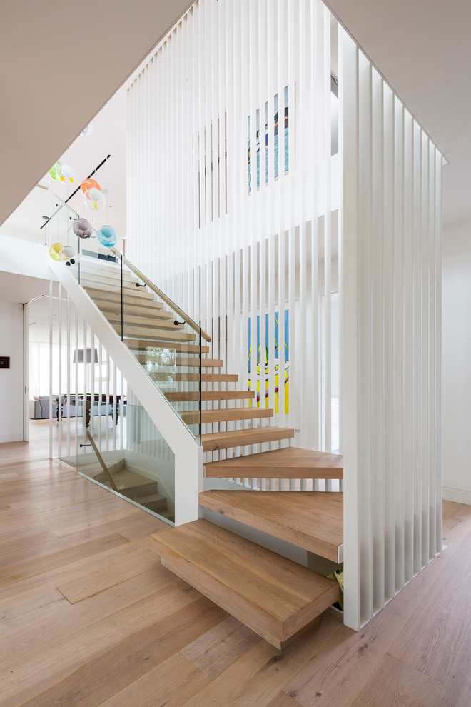 Diseño de escalera en L actual con escalones de madera y contrahuellas de madera