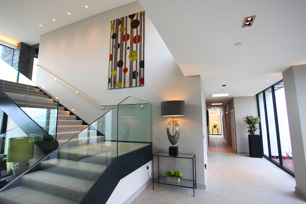 Inspiration for a large contemporary carpeted l-shaped staircase in Wiltshire with carpeted risers and feature lighting.