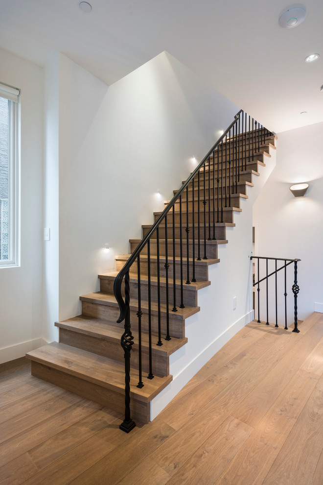 Photo of a medium sized contemporary wood curved staircase in Vancouver with wood risers and feature lighting.