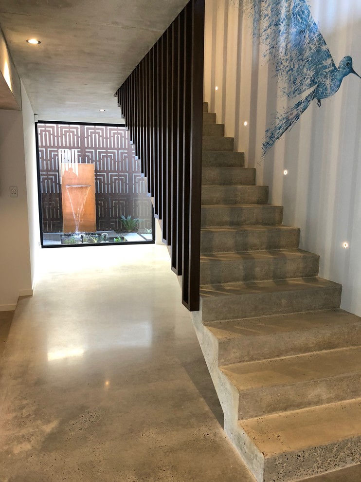 На фото: прямая бетонная лестница среднего размера в стиле лофт с бетонными ступенями и деревянными перилами с