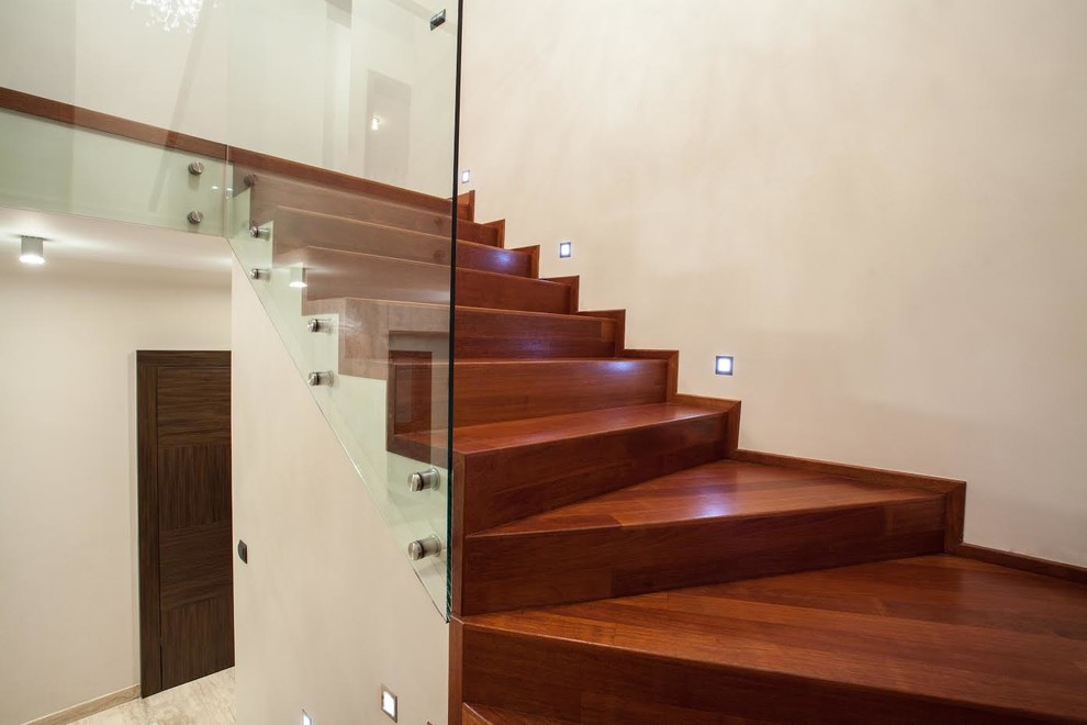 Inspiration for a mid-sized contemporary wooden curved glass railing staircase remodel in Miami with wooden risers