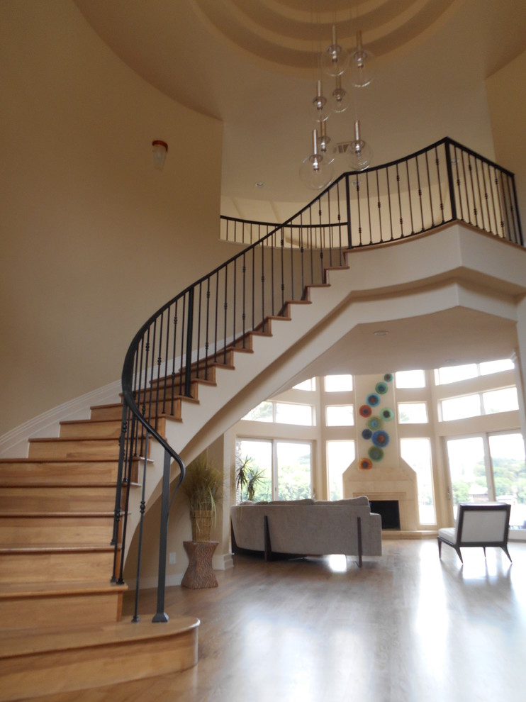 Mid-sized trendy wooden curved metal railing staircase photo in Houston with wooden risers