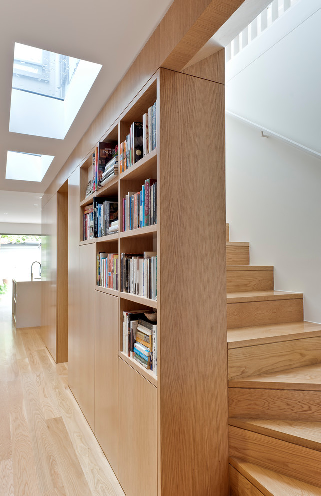 Cette photo montre un escalier courbe tendance avec des marches en bois, des contremarches en bois et un garde-corps en bois.