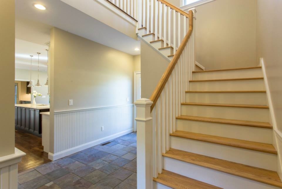 Large classic painted wood l-shaped staircase in New York with wood risers.