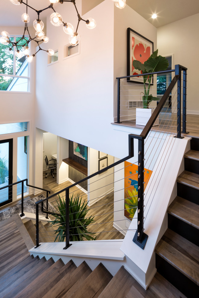 Свежая идея для дизайна: большая п-образная лестница в стиле модернизм с деревянными ступенями, крашенными деревянными подступенками и перилами из тросов - отличное фото интерьера