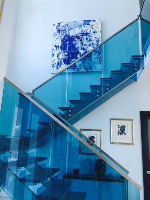 ニューヨークにある高級な中くらいなコンテンポラリースタイルのおしゃれな折り返し階段 (ガラスの蹴込み板) の写真
