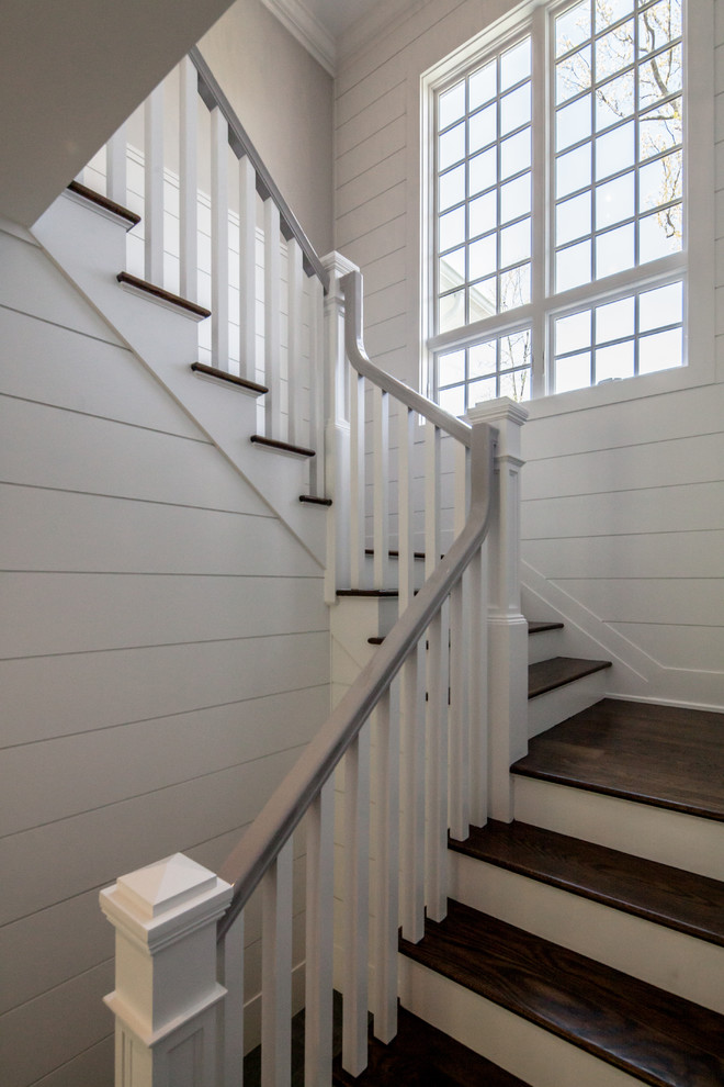 Inspiration pour un grand escalier peint traditionnel en L avec des marches en bois et un garde-corps en bois.