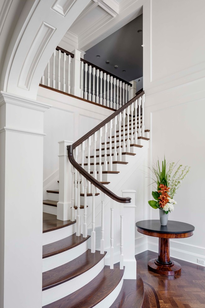 This is an example of a traditional wood l-shaped wood railing staircase in Boston with painted wood risers.