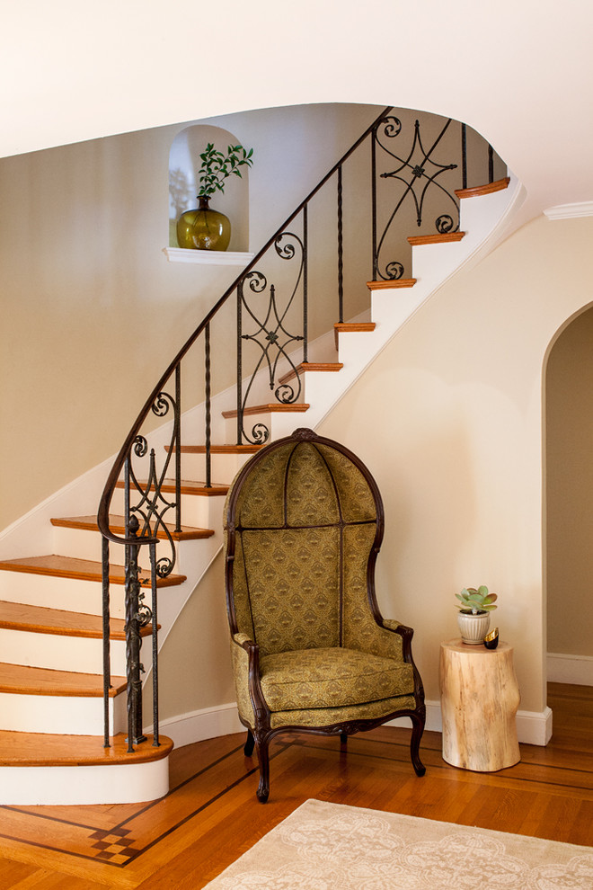 Ejemplo de escalera clásica con escalones de madera, contrahuellas de madera pintada y barandilla de metal