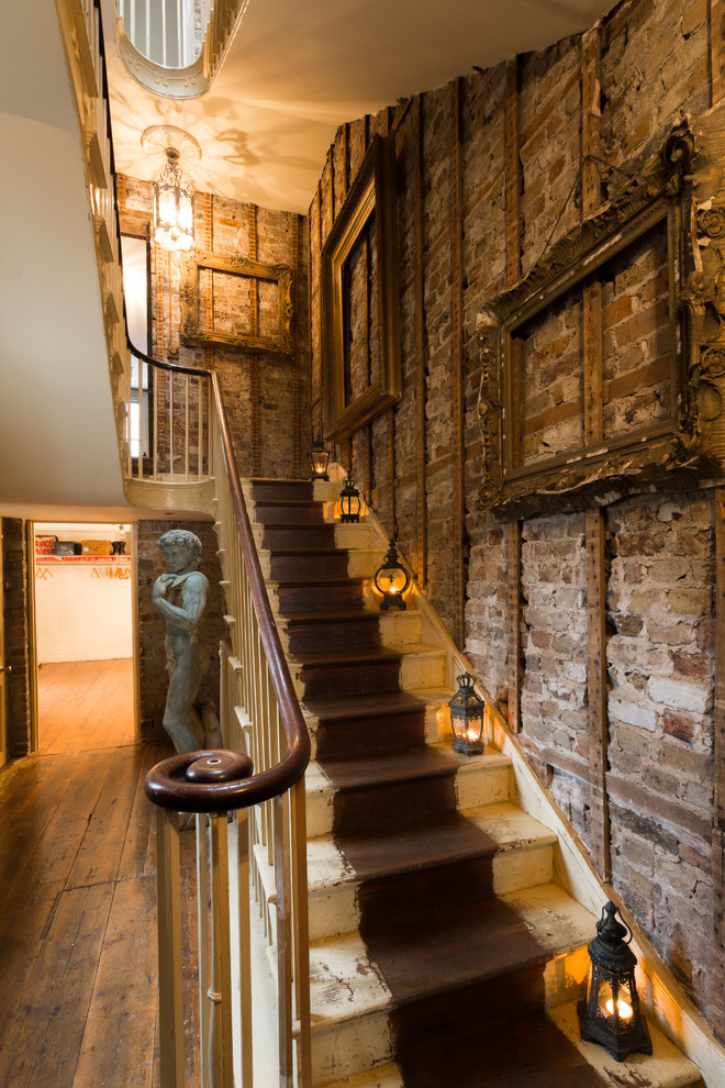 Vintage painted wood u-shaped staircase in London with painted wood risers and feature lighting.