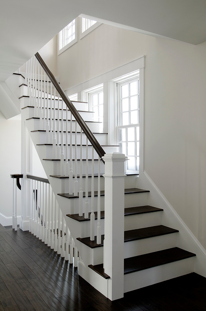Large nautical wood l-shaped staircase in Portland Maine with painted wood risers.