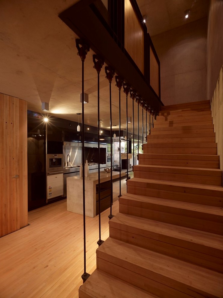 На фото: прямая бетонная лестница в стиле лофт с деревянными ступенями и металлическими перилами с