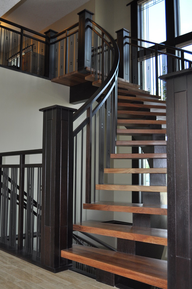 Ejemplo de escalera curva de estilo americano de tamaño medio sin contrahuella con escalones de madera