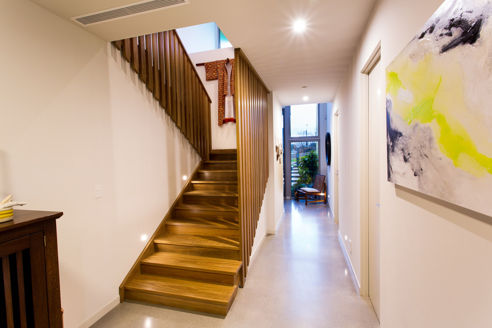 This is an example of a medium sized contemporary wood u-shaped wood railing staircase in Geelong with wood risers.