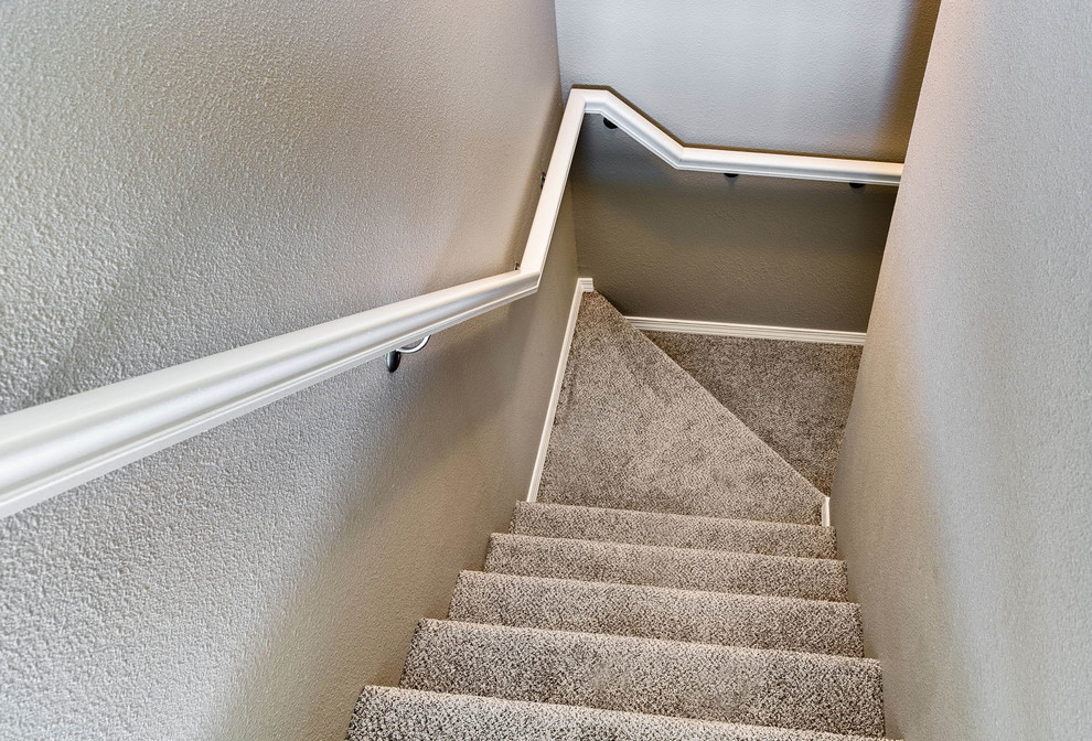 Cette image montre un petit escalier traditionnel en L avec des marches en moquette et des contremarches en moquette.