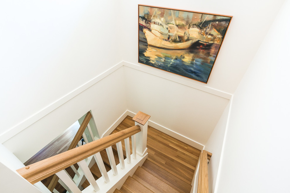 На фото: п-образная деревянная лестница среднего размера в стиле кантри с деревянными ступенями и деревянными перилами с