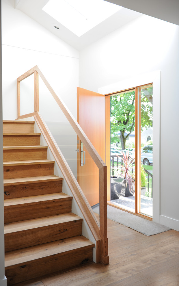 Esempio di una scala a "L" minimalista di medie dimensioni con pedata in legno, alzata in legno e parapetto in vetro