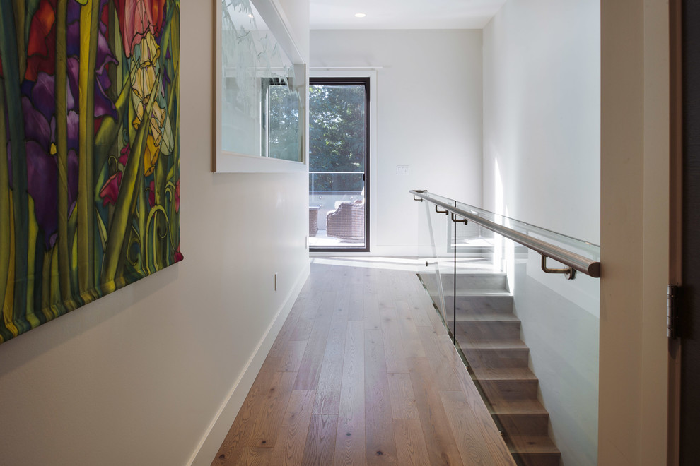 This is an example of a large contemporary wood straight metal railing staircase in Vancouver with wood risers.