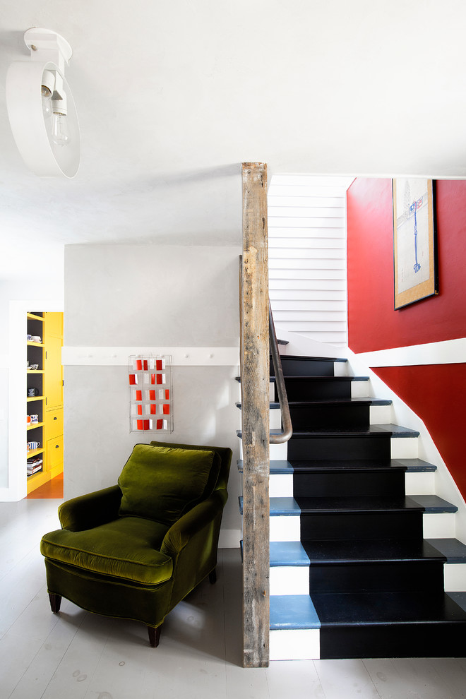 Ejemplo de escalera curva de estilo de casa de campo con escalones de madera, contrahuellas de madera y barandilla de metal
