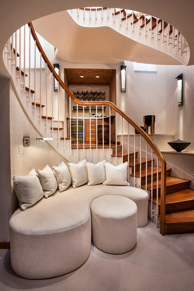 На фото: изогнутая деревянная лестница среднего размера в современном стиле с деревянными ступенями и деревянными перилами с