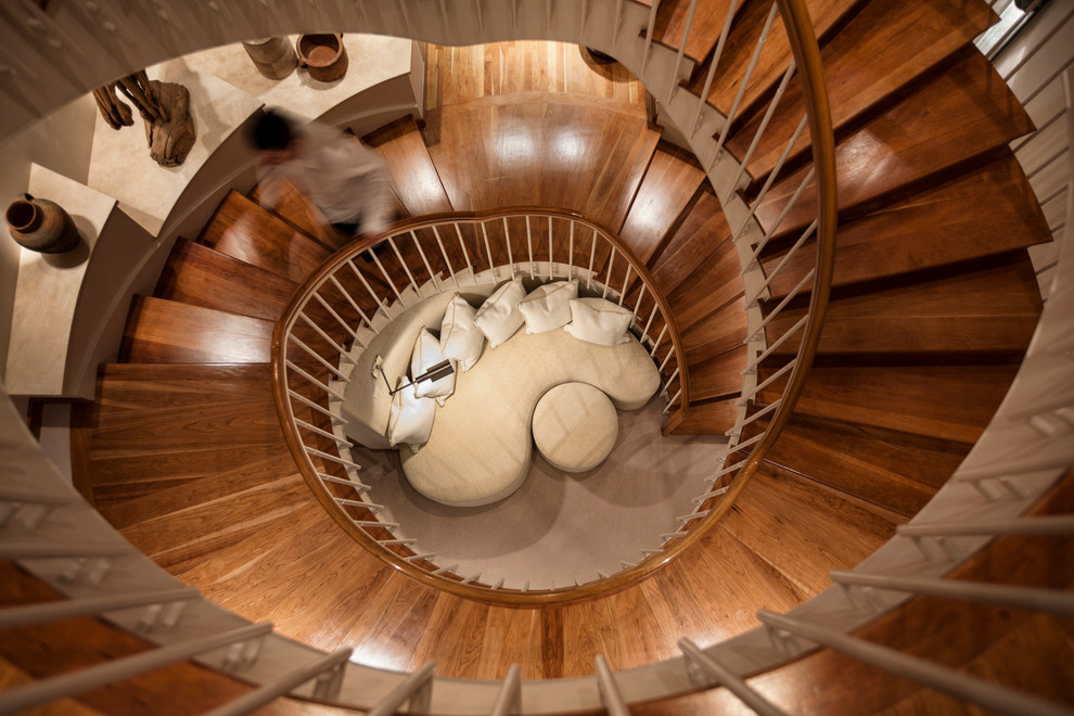 Стильный дизайн: огромная винтовая деревянная лестница в современном стиле с деревянными ступенями и деревянными перилами - последний тренд