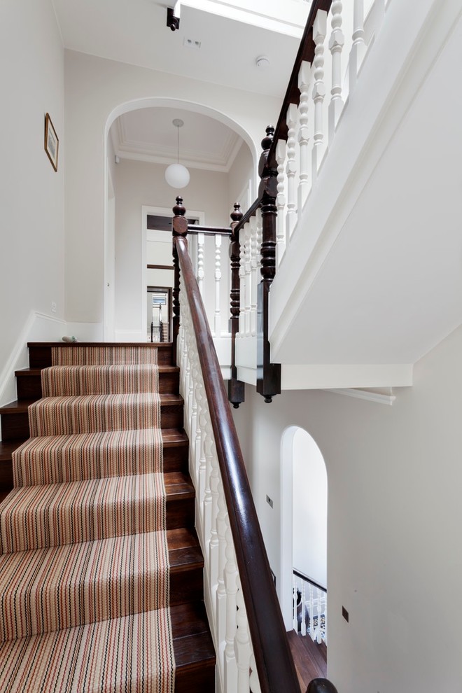 Design ideas for a medium sized traditional carpeted straight wood railing staircase in London with carpeted risers.