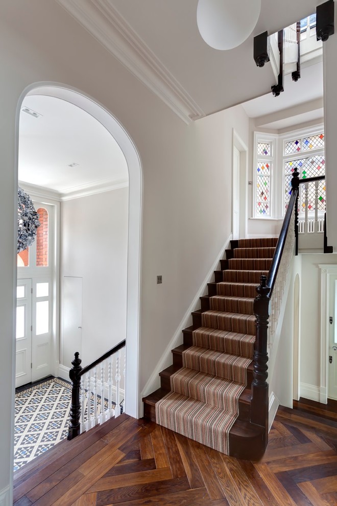 This is an example of a large victorian wood straight wood railing staircase in London with wood risers.