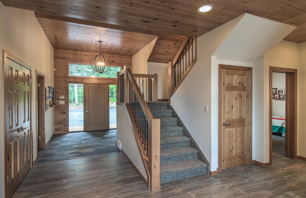 На фото: п-образная деревянная лестница в стиле рустика с ступенями с ковровым покрытием