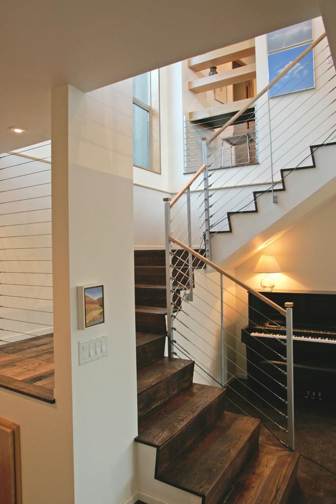 Ejemplo de escalera curva actual de tamaño medio con escalones de madera y contrahuellas de madera