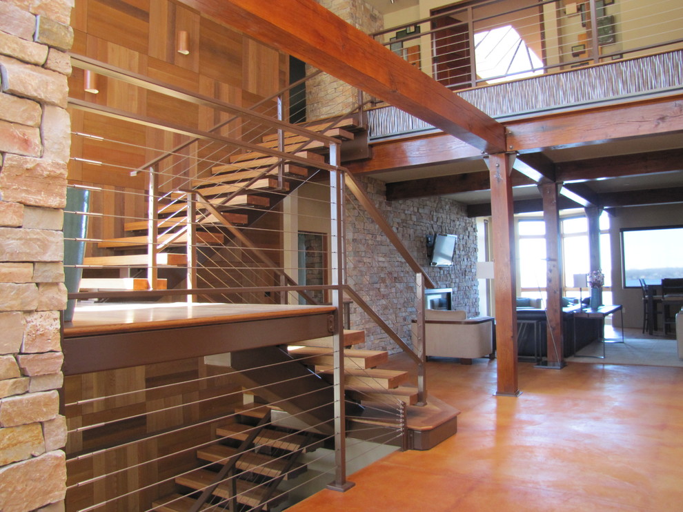 Cette image montre un escalier sans contremarche droit design de taille moyenne avec des marches en bois, un garde-corps en câble et éclairage.