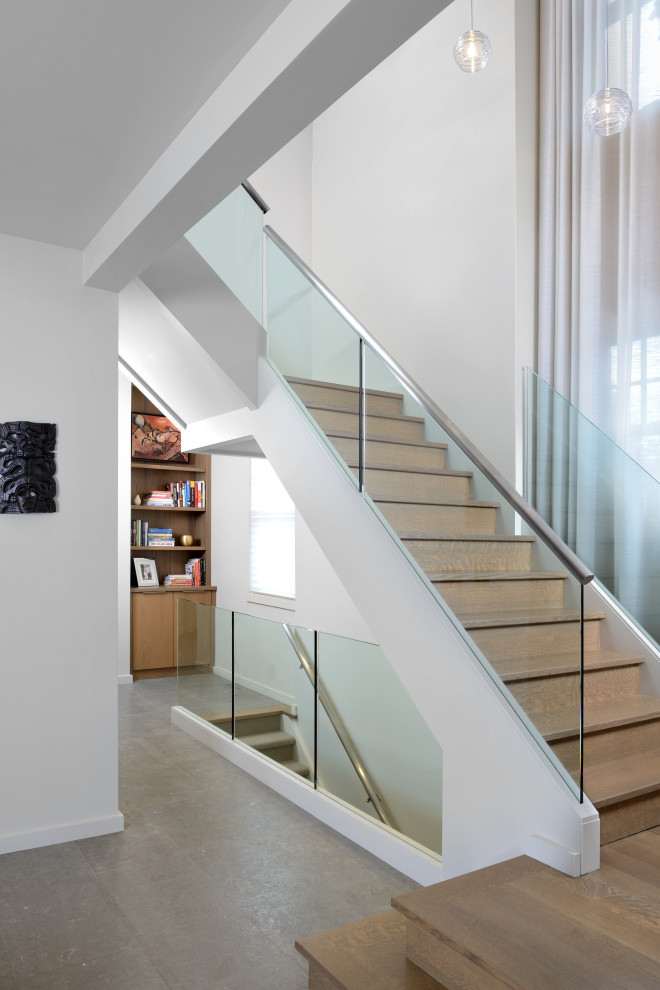 Imagen de escalera en L moderna grande sin contrahuella con escalones de vidrio, barandilla de metal y papel pintado