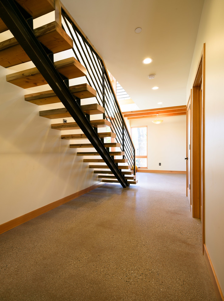 Cette image montre un escalier droit design de taille moyenne avec des marches en bois, des contremarches en métal et un garde-corps en bois.