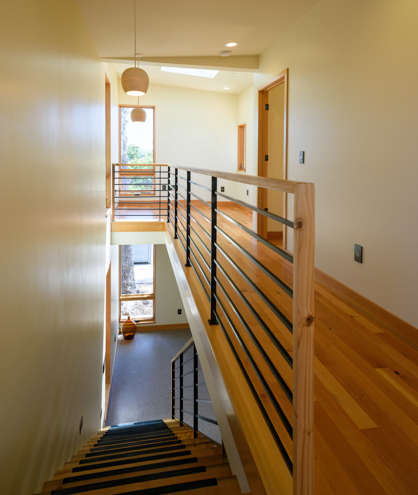 Modelo de escalera recta contemporánea de tamaño medio con escalones de madera, contrahuellas de metal y barandilla de madera