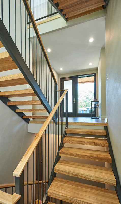 Design ideas for a contemporary wood u-shaped metal railing staircase in Other with open risers.